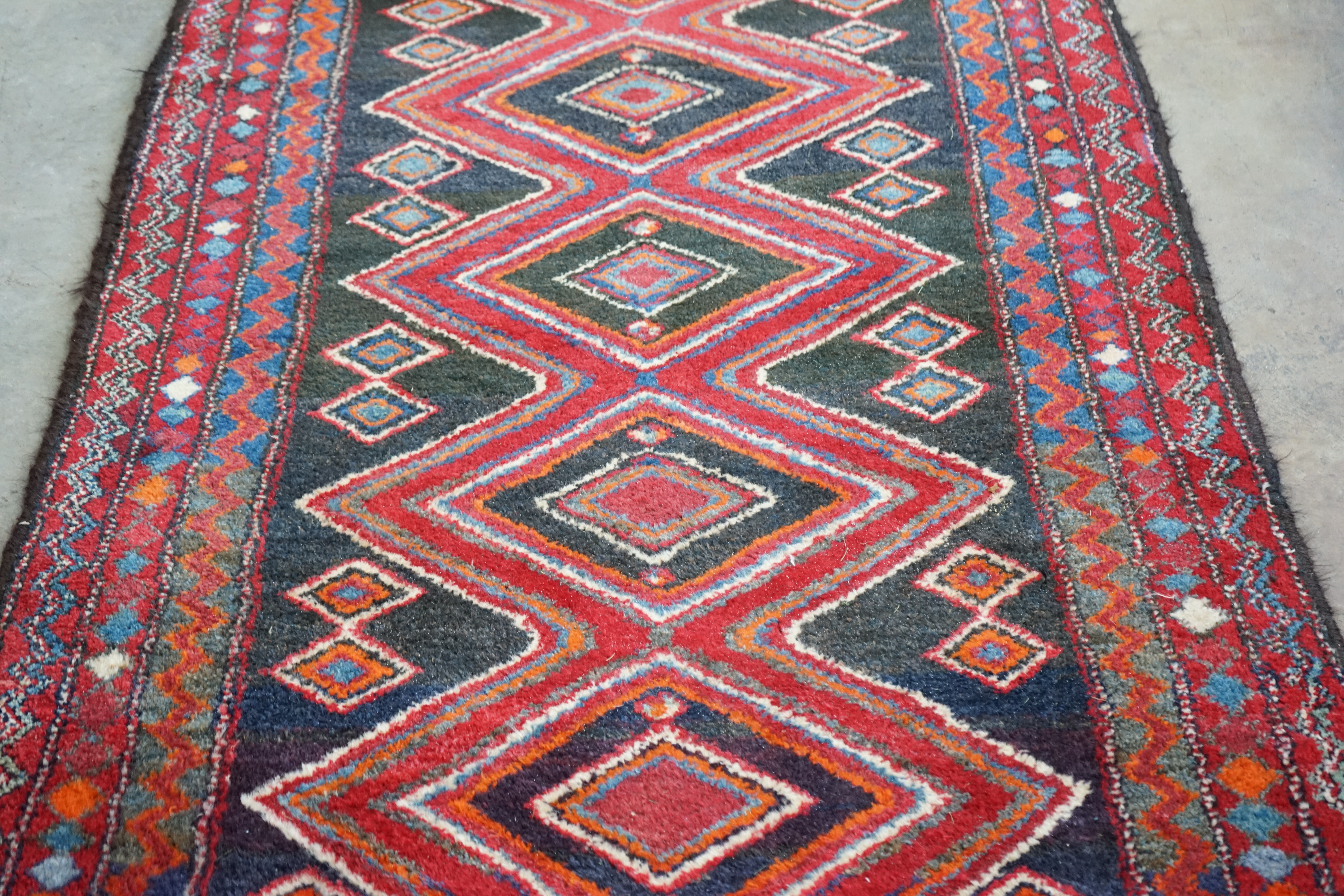 A Belouch blue and red ground rug, 256 x 116cm